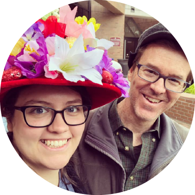 A selfie of two people smiling. One person wears a silly hat.