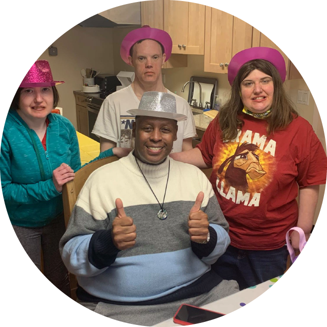 Four people group together wearing funny hats