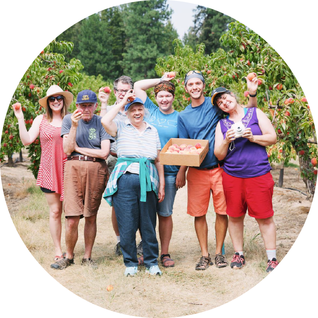 A group poses together at an apple orchard