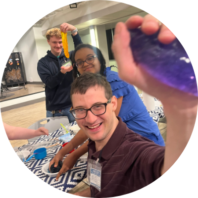 Three community members smile while making slime together Three community members smile while making slime together